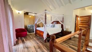 a bedroom with a canopy bed and a red chair at Tranquil Villas in Soufrière +42 photos