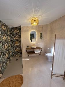 a bathroom with a sink and a toilet and a mirror at Boutique de Bella - Rustic House with a Wine Cellar in Calderón +35 photos