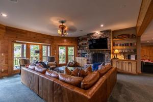 sala de estar con sofá grande y chimenea en A High Country Retreat, en Boone
