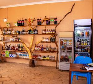 a store with a tree on the wall next to a refrigerator at Amboseli Likizo Lodge in Kimana