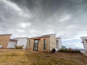 une petite maison sur le côté d'une cour dans l'établissement Gîte Douceur & Évasion avec Spa Privatif pour 2 - Vue Océan - FR-1-786-71, à Saint-Gilles-les Hauts