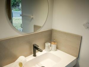 une salle de bain avec un lavabo et un miroir dans l'établissement Gîte Douceur & Évasion avec Spa Privatif pour 2 - Vue Océan - FR-1-786-71, à Saint-Gilles-les Hauts