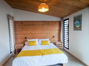 une chambre avec un grand lit avec des oreillers jaunes dans l'établissement Gîte accessible avec spa privatif et terrasse - FR-1-786-73, à Fleurimont