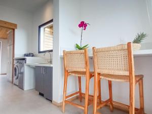 - une cuisine avec 2 chaises et un comptoir avec évier dans l'établissement Gîte accessible avec spa privatif et terrasse - FR-1-786-73, à Fleurimont