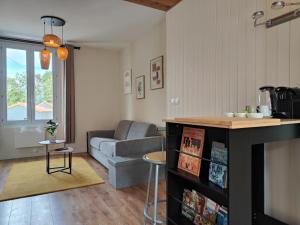 eine Küche und ein Wohnzimmer mit einer Couch und einem Tisch in der Unterkunft Cocon du Tisserand - Centre ville - Cosy et Intimiste in Cholet + 17 Fotos