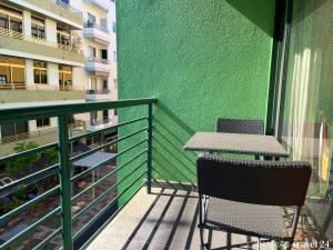 two chairs and a table on a balcony with a green wall at Versicolor in Los Llanos de Aridane