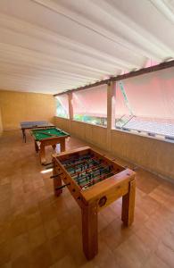 two ping pong tables sitting in a room with avertisementvertisement at Sítio Solar de Espanha in Duque de Caxias