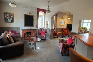 a living room with couches chairs and a fireplace at Samuel Fox, Bradwell Hope Valley in Bradwell