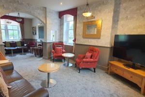 a living room with red chairs and a flat screen tv at Samuel Fox, Bradwell Hope Valley in Bradwell