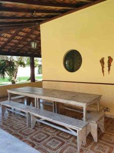 a wooden picnic table in a room with a window at Sítio Solar de Espanha in Duque de Caxias