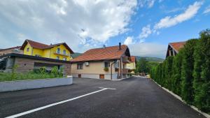 a yellow house on the side of a road at Woodland in Korenica