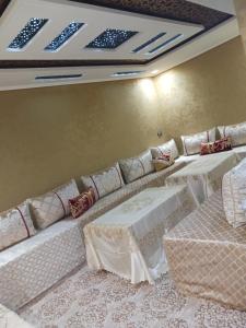 a room with two tables and a couch with chairs at Khenifra in Khenifra +1 photo