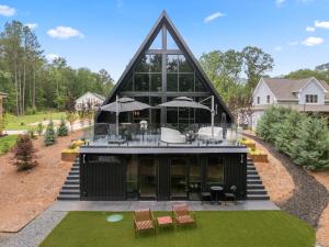 una vista esterna di una casa con un grande edificio di Midnight Raven Lake House - luxury a-frame w boat a Reed Creek
