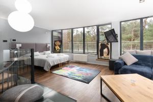 a living room with a bed and a couch at Baltica Heaven by 2HomeRent - przestronne apartamenty premium przy samej plaży in Rogowo +161 photos