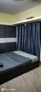 バンガロールにあるsahithya comfort homestayの青いベッドバイザー付きの客室のベッド1台分です。 +4枚の写真