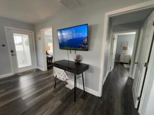 a room with a desk with a television on the wall at Pelican Fresh Entire Unit Kit Washer Dryer Upstairs 3Mi to Beach in Bonita Springs