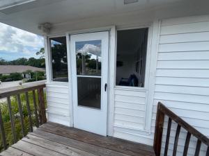 a porch with a white door on a house at Pelican Fresh Entire Unit Kit Washer Dryer Upstairs 3Mi to Beach in Bonita Springs