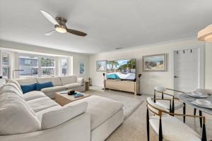 a living room with a white couch and a tv at Siesta Key Waterfront Oasis - Heated Pool, Dock, Walk to Village & Beach in Bailey Hall