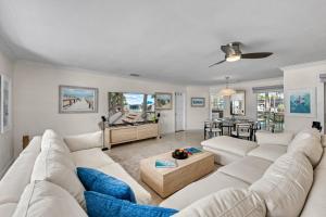 a living room with a white couch and a table at Siesta Key Waterfront Oasis - Heated Pool, Dock, Walk to Village & Beach in Bailey Hall