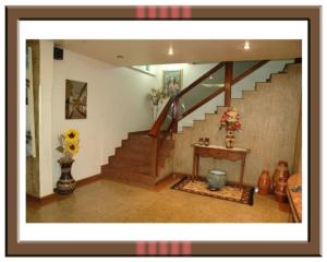 a living room with a staircase with a table and flowers at Hotel Walsa in Paracatu