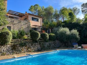 a villa with a swimming pool in front of a house at Le Figuier appart 2-3 pers en plein vignoble avec piscine privée à 30mn des gorgesdu Verdon et des plages in Carcès