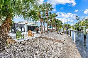 a house on the water with palm trees at Siesta Key Waterfront Oasis - Heated Pool, Dock, Walk to Village & Beach in Bailey Hall