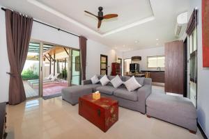 a living room with a couch and a ceiling fan at 2 bedrooms pool and garden villa Niche 9 Rawai in Ban Nong Chaeng