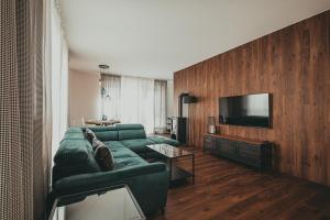 a living room with a green couch and a flat screen tv at Baltica Heaven by 2HomeRent in Rogowo