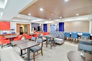 a dining room with tables and chairs at Holiday Inn Express & Suites Palm Coast - I-95 in Palm Coast