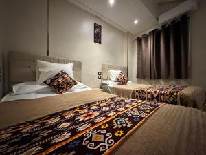 a hotel room with two beds and a window at Grand Duplex in Aswan