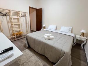a bedroom with a large bed with two towels on it at Casa Sabiá - Jaguariúna in Jaguariúna