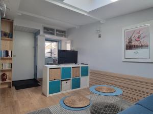 a living room with a tv and a blue couch at T1 rez de jardin proche mer in Plérin