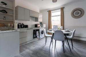 een keuken met een tafel en een tafel met stoelen bij 3 Bed House - Sleeps 5 - Parking - Wifi in New Brancepeth +2 foto's