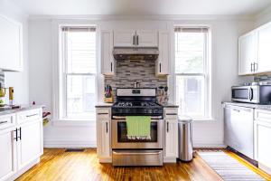 a kitchen with white cabinets and a stove top oven at Short North Convention King Bed Free Parking! in Columbus