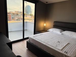 a bedroom with a large bed and a large window at LA Luxury Rooftop in Tirana