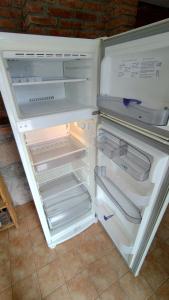 an empty refrigerator with its door open in a kitchen at Escalera de Piedra in Tilcara