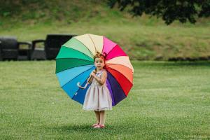 Una niña sosteniendo un paraguas colorido en un campo en Empyrean Birtokház, en Hédervár 3 fotos más