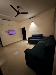 a living room with a couch and a ceiling fan at Fleur Haus in Kappil