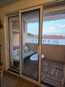 un balcon avec des portes coulissantes en verre avec un canapé dans l'établissement Magnifique appartement, à Salon-de-Provence