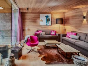 a living room with a couch and a table at Smaragdresort Gipfelstürmer in Bramberg am Wildkogel