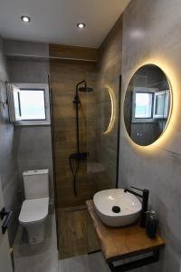a bathroom with a toilet and a sink and a shower at twins luxury studios in Kastoria +13 photos
