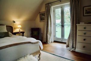 a bedroom with a bed and a sliding glass door at Charlbury country retreat - sleeps 10 in Charlbury