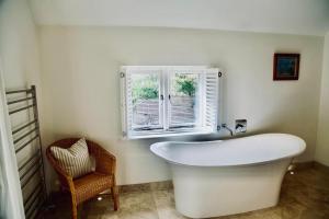 a white bath tub in a bathroom with a window at Charlbury country retreat - sleeps 10 in Charlbury +23 photos