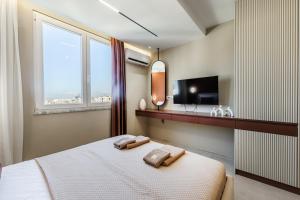 a bedroom with a bed with two towels on it at Marina Luxury Jacuzzi Suites by PS in Durrës