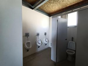 een badkamer met drie urinoirs en drie toiletten aan de muur bij Portuguese Sailboat Experience I in Lissabon