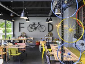 a restaurant with tables and chairs and a bicycle on the wall at Mercure Reims Parc Des Expositions in Reims