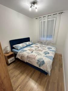 a bedroom with a bed and a window at Apartman Maja in Budžak