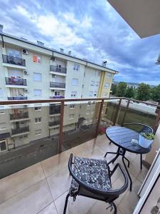 a balcony with a table and a chair and a building at Apartman Maja in Budžak