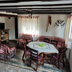 a living room with a table and chairs and a couch at Cabana NEDA in Rausor +14 photos