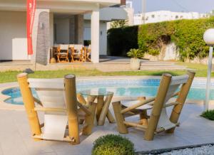 a couple of chairs and a table next to a pool at Villa Oliviera in Akouda +26 photos